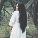 shallow focus photography of woman in white mini dress near tress