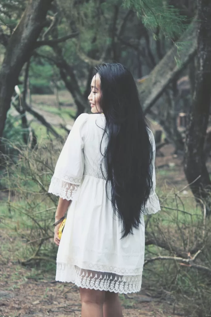 shallow focus photography of woman in white mini dress near tress